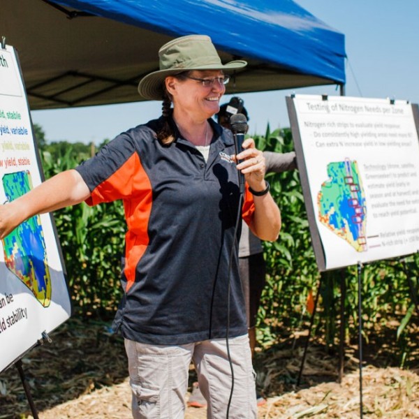 Quirine Ketterings standing in front of a poster outside speaking into a microphone