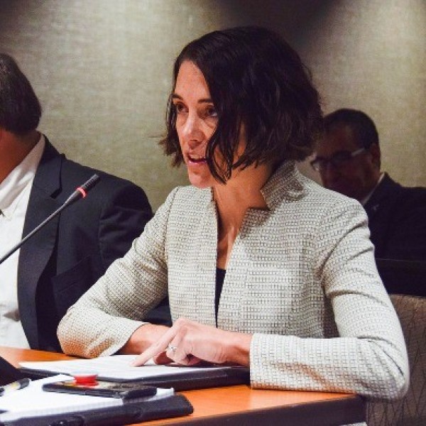 Gretchen Goldman '06 siting at a table and speaking