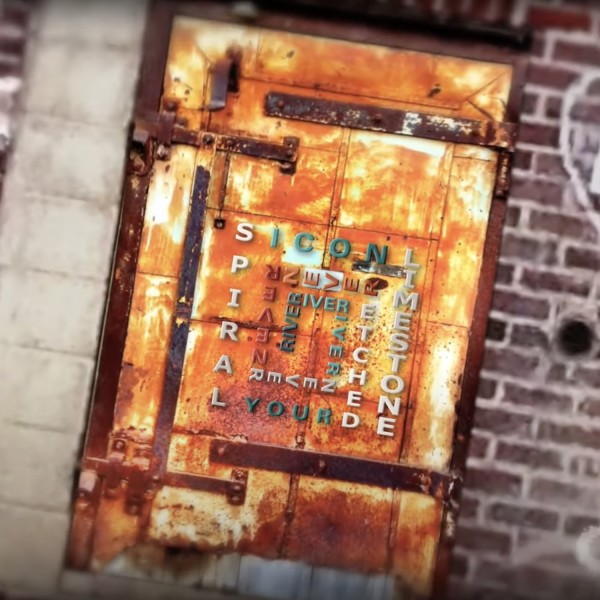 Photo of a rusty door with magnetic letters on it creating a square-shaped spiral.