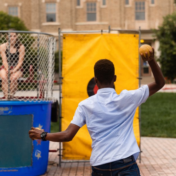 A student throws a ball at a dunk tank