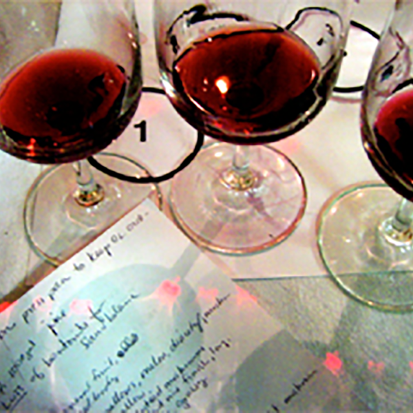 Three cups of red wine in a table.