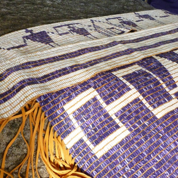 Photo of three wampum belts made with white and purple colored carved shells as beads.