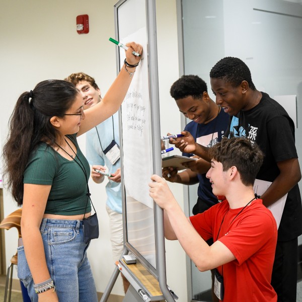 Youths working together on a whiteboard