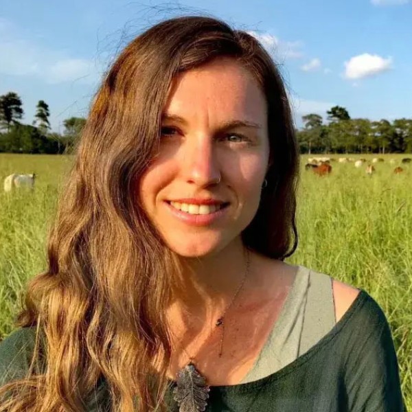A headshot photo of Bryony Sands in a sunny field