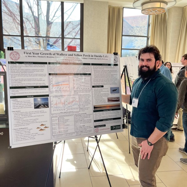 person standing next to poster at conference