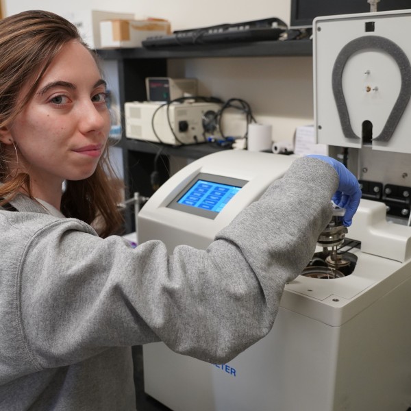 a woman puts a sample into a bombcalorimeter