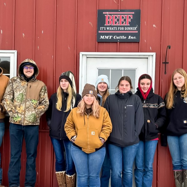 a group of young people stand together in front of a building