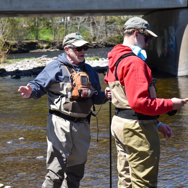 A Trout Unlimited volunteer on stream with a 4-H youth participant