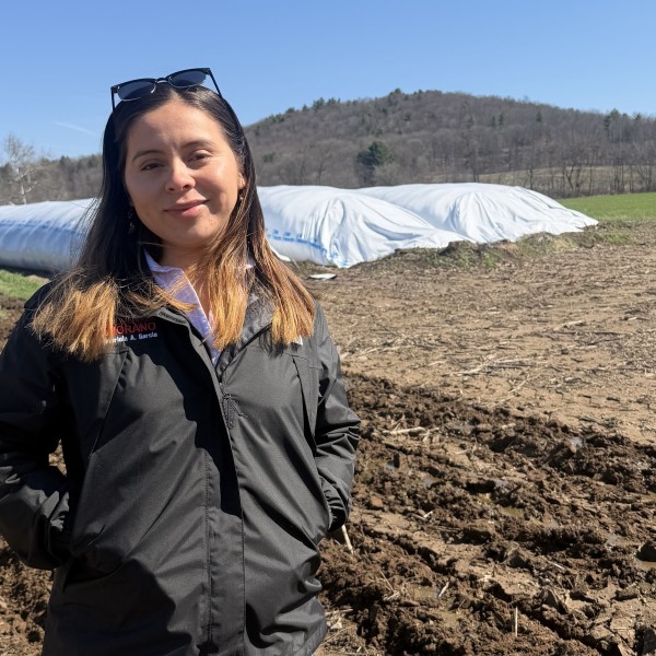 A woman stands in a field.