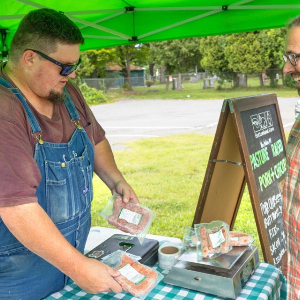 Matthew LeRoux (right), Cornell extension associate and founder of MeatSuite, talks with MeatSuite-user Bill Morse of Bottomland Farm at the East Hill Plaza Farmers’ Market on Aug. 19.