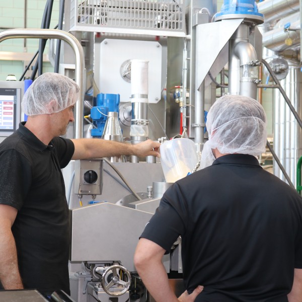 Two men working at an extruder machine