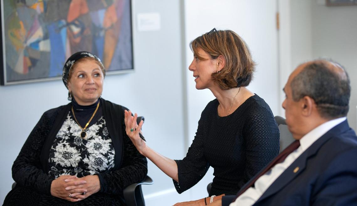 Two women and a man sitting and talking to one another
