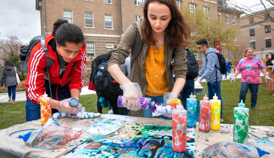 Students tie-dying tshirts outside 