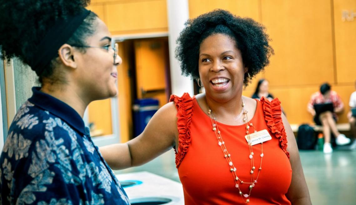 Two women speak with each other