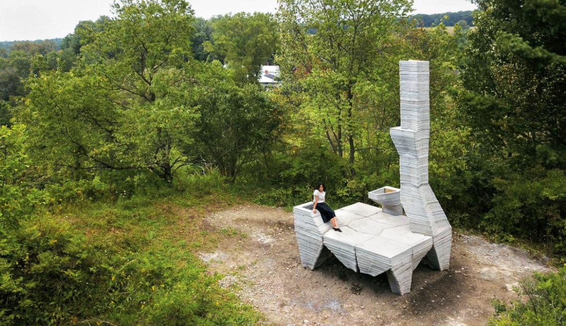 A woman sitting on the foundation of a house