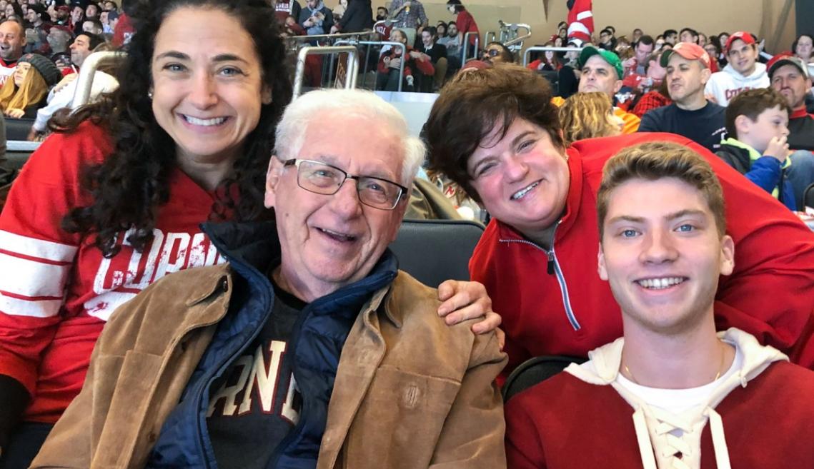Three generations of a family sit smiling in Cornell gear
