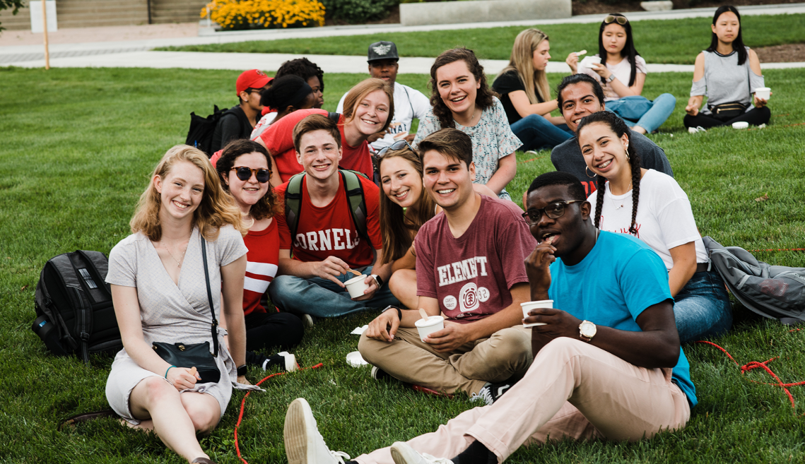 students sit on the grass eating ice cream
