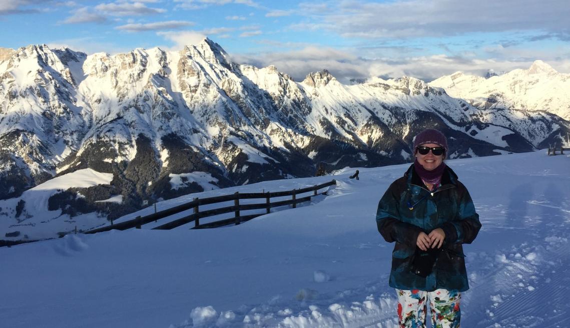 Person standing in front of mountains in snow