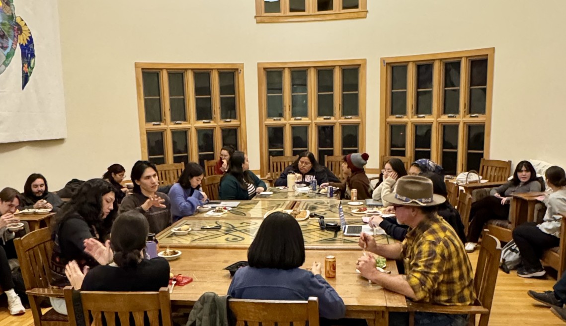 A group of people dine in the Akwe:kon Great Room.