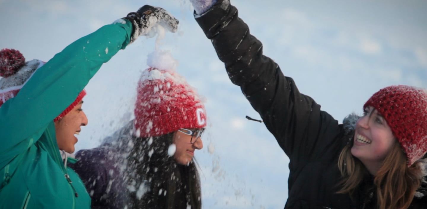 Three students having a snow ball fight