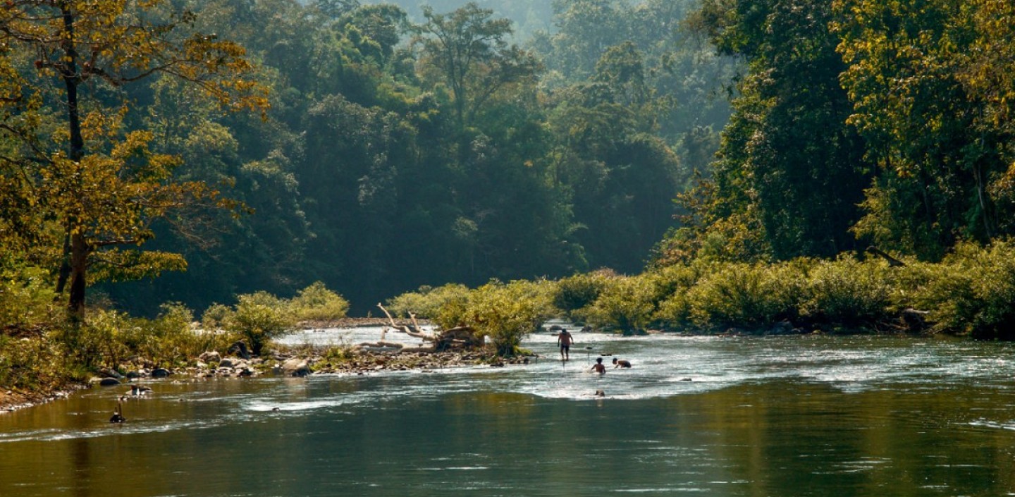 People standing in a river spearing fish