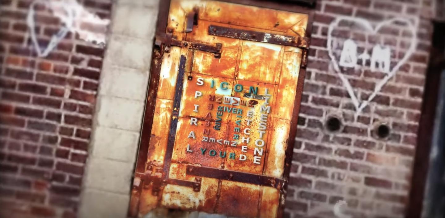 Photo of a rusty door with magnetic letters on it creating a square-shaped spiral.