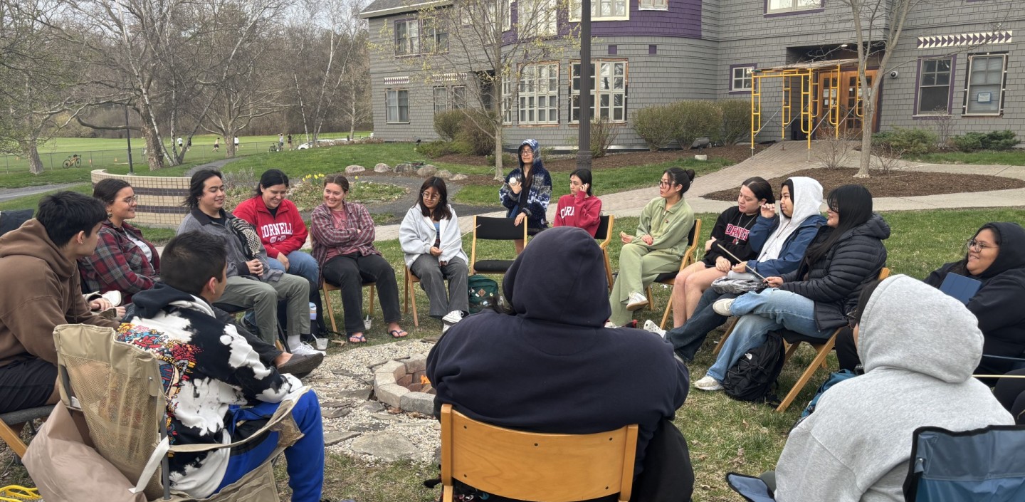 Students sit around a fire