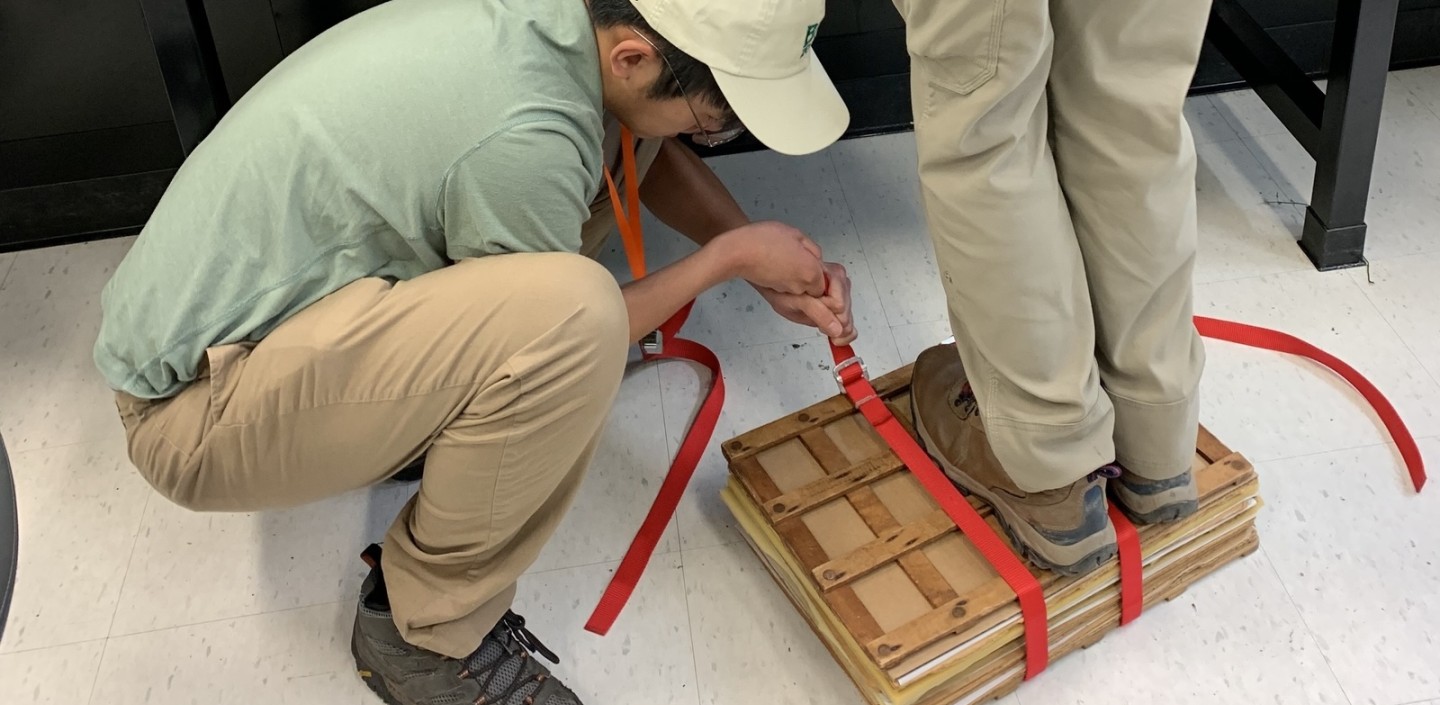 2 students working together to flatten plant press
