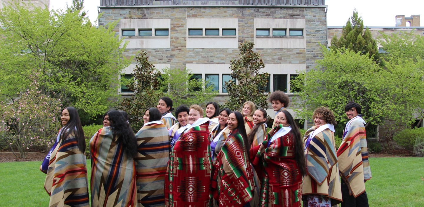 Students stand in a courtyard with blankets.
