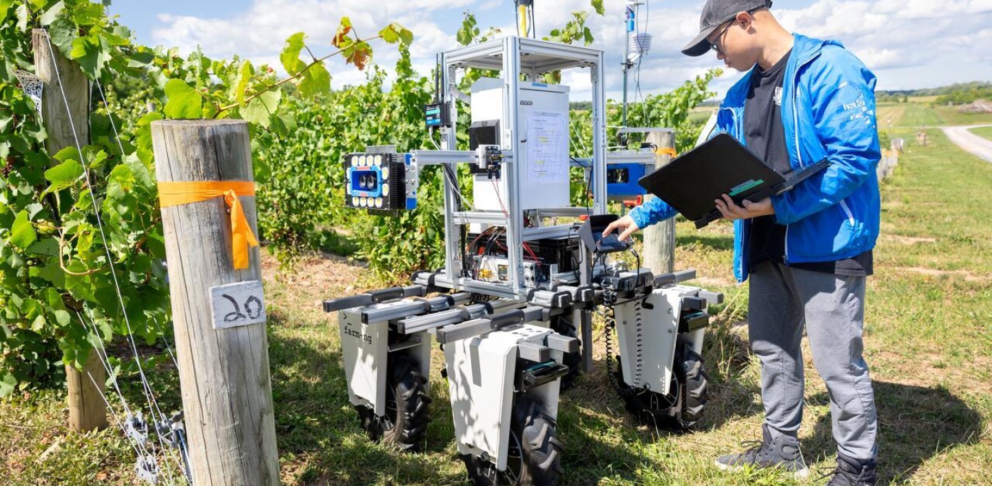 A student working with a robot in the field.