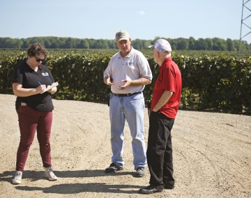 Three people talking at a farm
