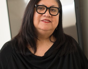 A photo of Jolene Rickard smiling for the camera in glasses and a black shirt.