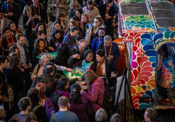 A crowd of people standing around a colorful food truck