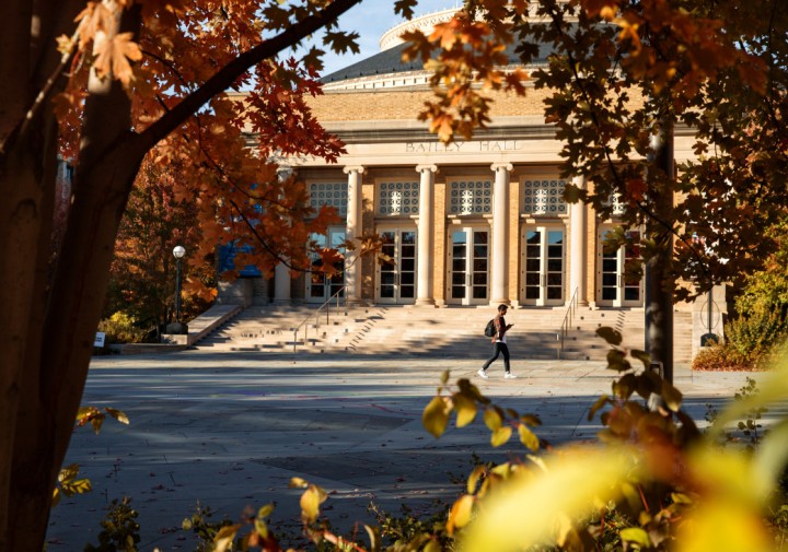 A student walking outside in the fall