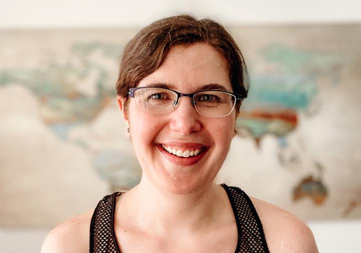 Megan Greischar standing in a room with a map on the wall behind her