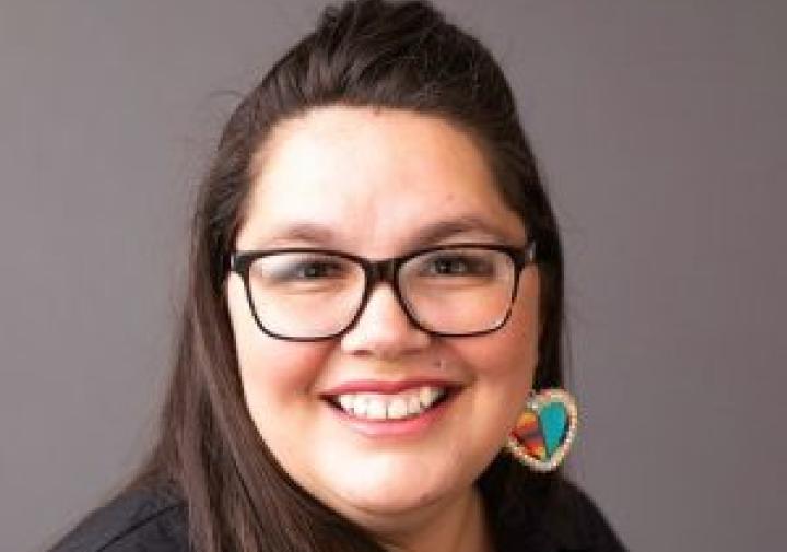 Portrait photo of a woman wearing glasses and earings.