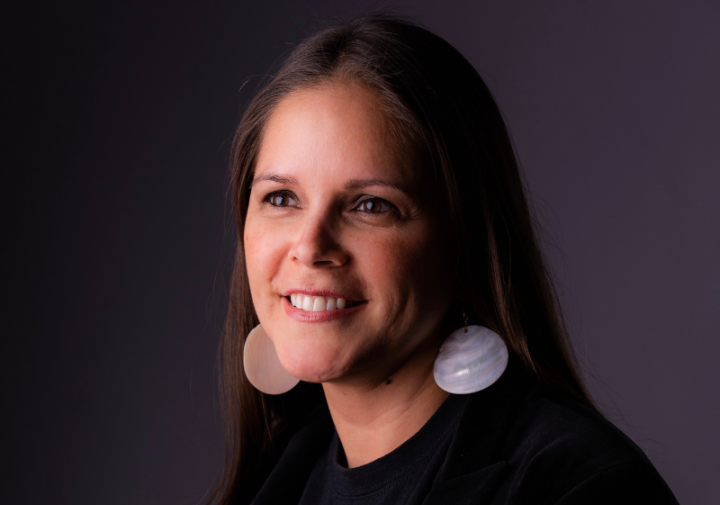 Headshot photo of a woman wearing a shirt that says rematriation magazine.