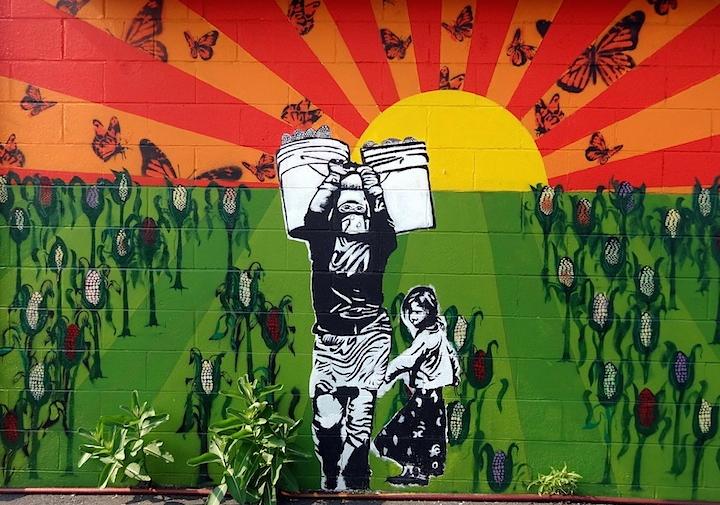Mural of person carrying buckets through a corn field