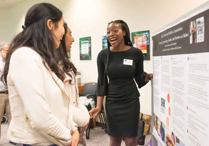 Two women stand in front of poster presentation