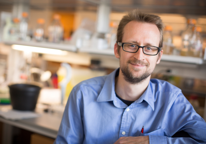 a man in a blue shirt sits in a lab