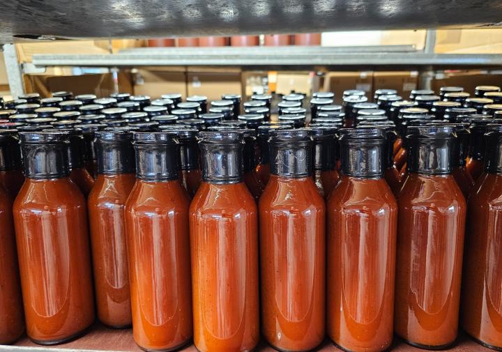 Bottles of hot sauce filled and sealed.