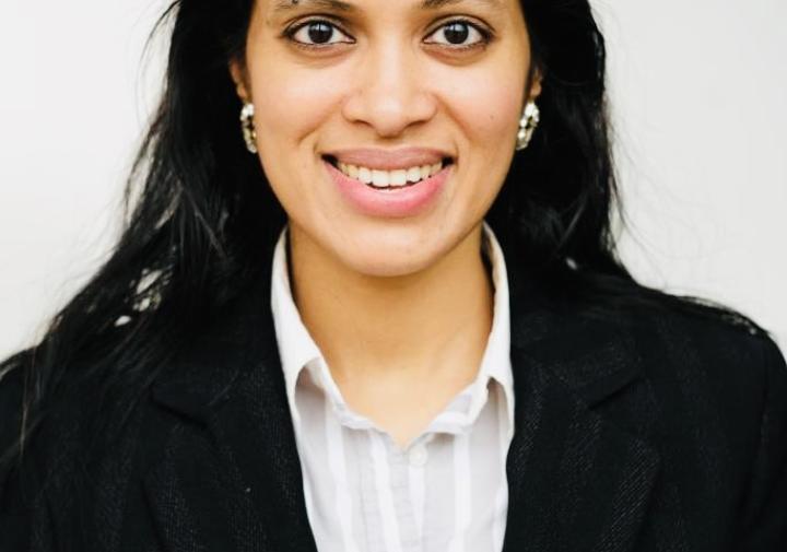 Person in a black blazer standing in fornt of a wall