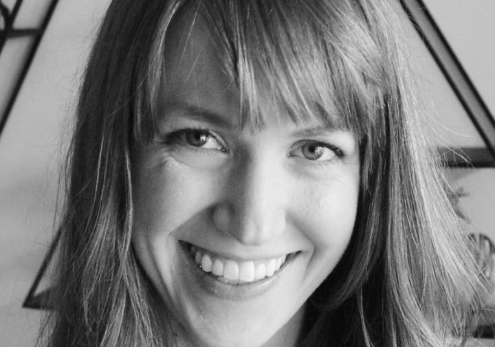 Person in a black shirt standing in front of wall art