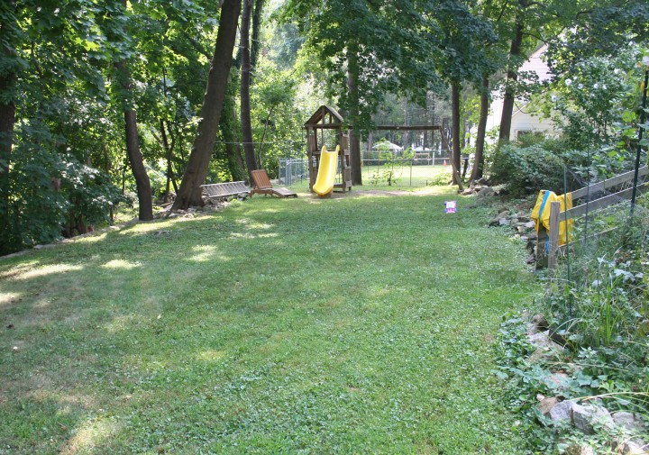 shady backyard with a kids play gym