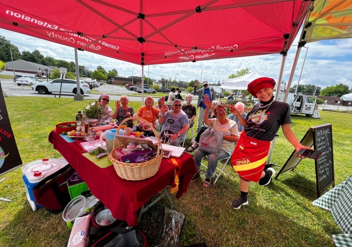 Farmers Market visitors watch a cooking demonstration 