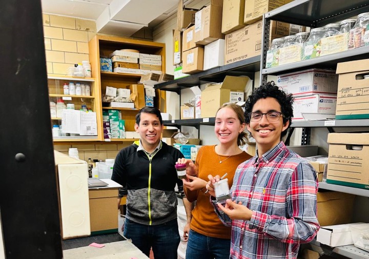 Three people stand next to each other in a lab.