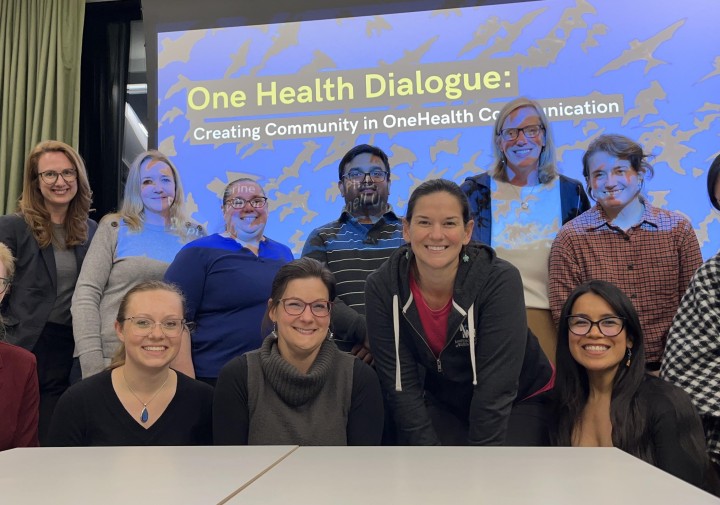 people smile in front of screen that reads One Health Dialouge