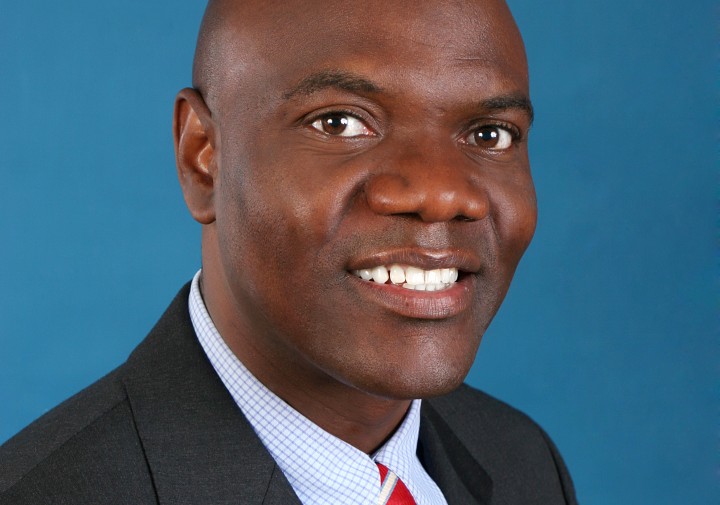 Professional portrait of a man wearing a suit jacket, shirt and red tie.