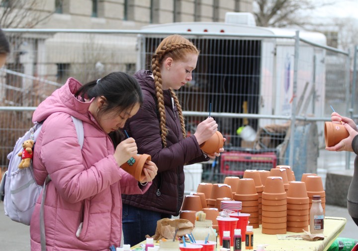 Student decorate clay flower pots