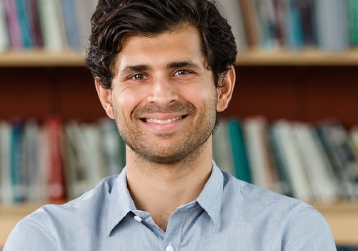 Professor Usmani standing in a library